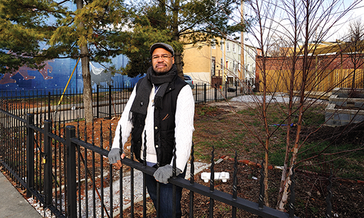 Baltimore resident Christopher Redwood stands at the entrance gate of a green public space in West Baltimore. Credit: Michael W. Fincham